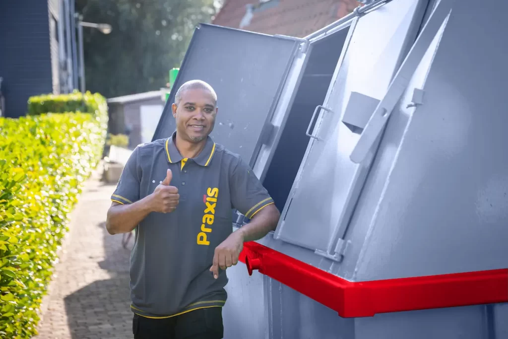 Een chauffeur met duim omhoog naast een container