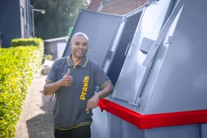 Een chauffeur met duim omhoog naast een container