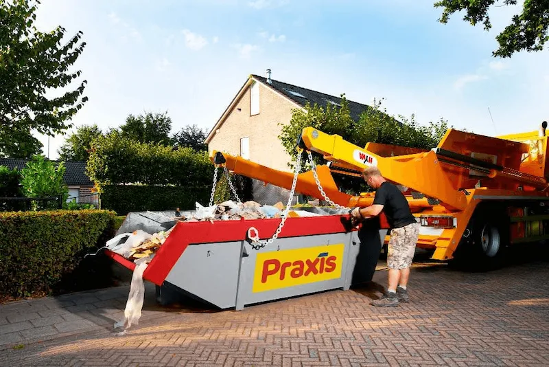 Volle container aan de weg wordt opgehaald door een chauffeur.